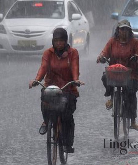 Dua orang pesepeda menembus hujan lebat di jalan Merdeka Selatan Jakarta