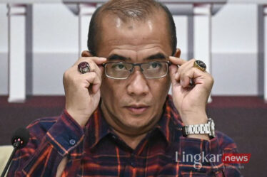 Ketua KPU Hasyim Asyari membetulkan posisi kacamata