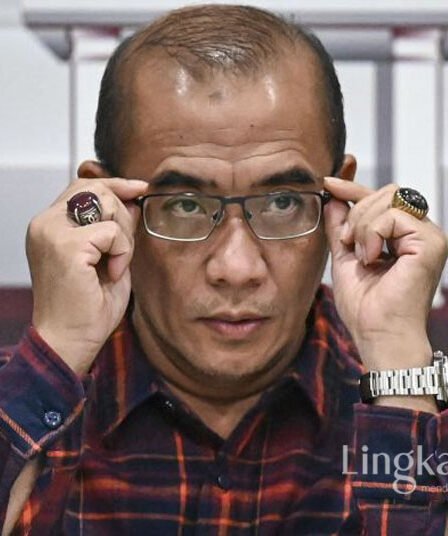 Ketua KPU Hasyim Asyari membetulkan posisi kacamata
