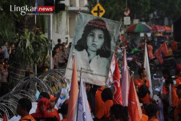 Simpatisan dari Partai Buruh membentangkan poster wajah Marsinah saat berunjuk rasa