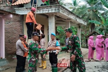 Petugas gabungan bersama warga memperbaiki atap genteng