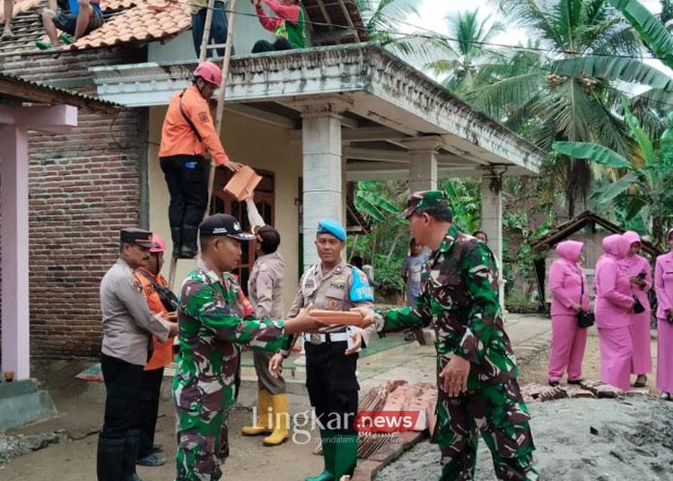 Petugas gabungan bersama warga memperbaiki atap genteng