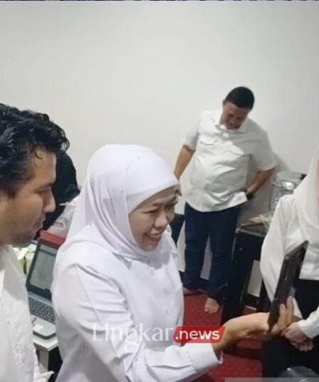 Pasangan Calon Gubernur dan Wakil Gubernur Jawa Timur Khofifah Indar Parawansa Emil Elestianto Dardak saat menerima telepon dari Presiden ke 7 RI Joko Widodo di posko data center Surabaya Rabu